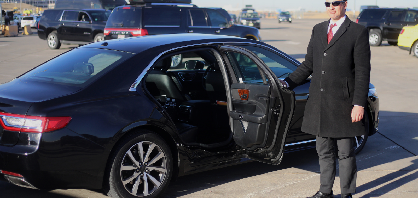 CLT Car Charlotte town car service — professional chauffeur opening luxury sedan door
